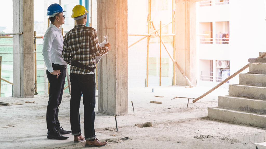 Artisan qualifié inspectant une installation électrique sur chantier de rénovation haut de gamme